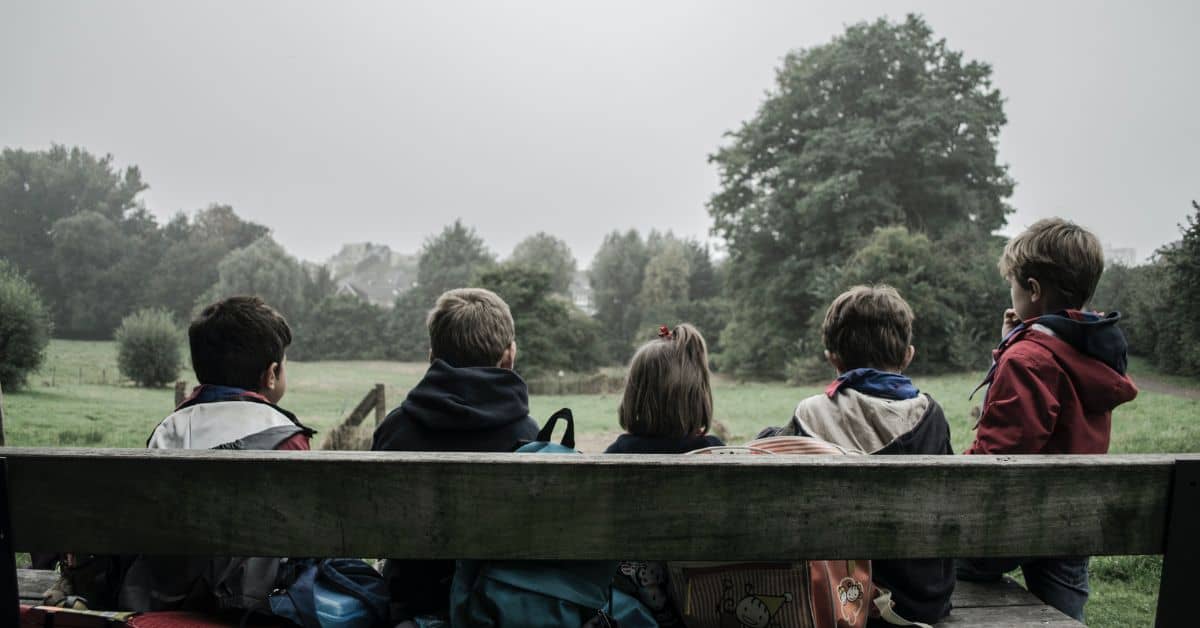 Niños y niñas sentados en el parque